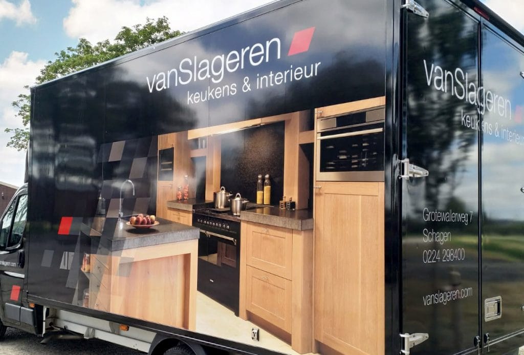 Studioviv biedt opvallende voertuigbelettering, zoals een zwart busje met "vanSlageren keukens & interieur" branding.